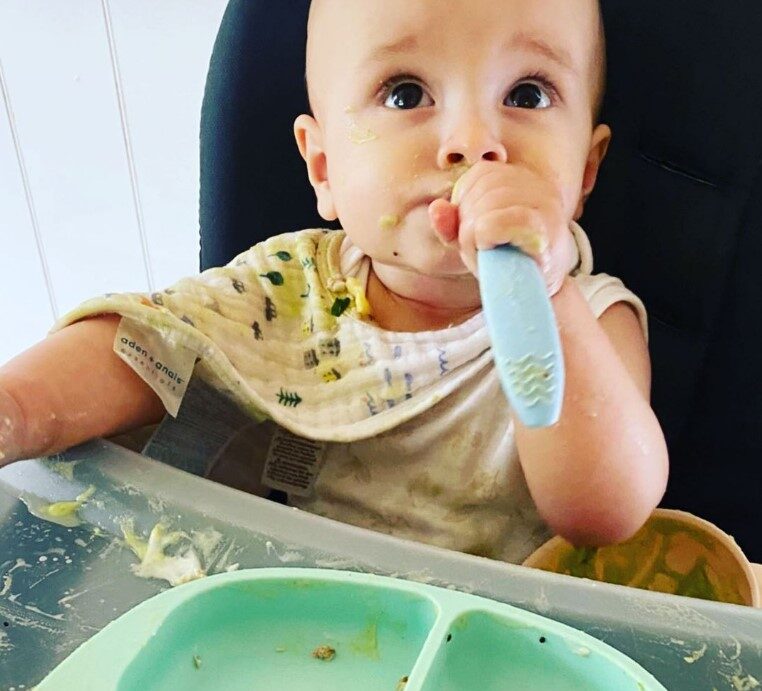 Toddler using Cuddle Bug & Co bowl and spoon to eat their thermomix recipe.
