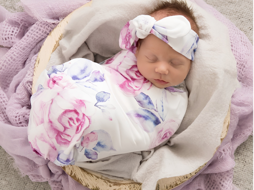 Newborn baby wrapped in floral swaddle blanket