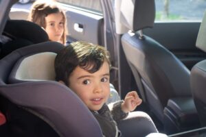 Young child seated in a child car seat in the back of a vehicle. 